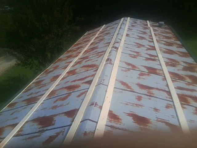 Rusted metal roof panels with new wood purlins before replacement — Storm Damage Roof Repair in Genoa by Roofing Brothers